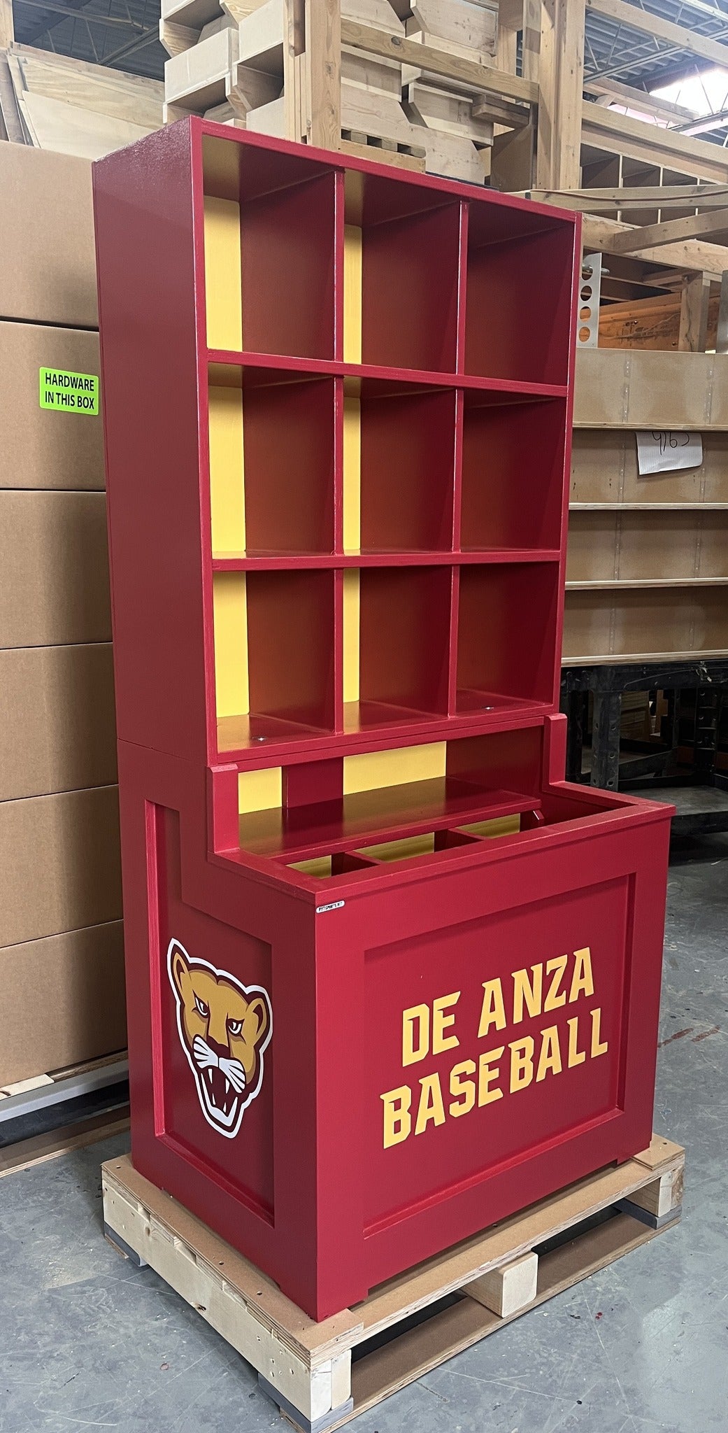 Red storage unit with 'De Anza Baseball' text and panther logo on a pallet.