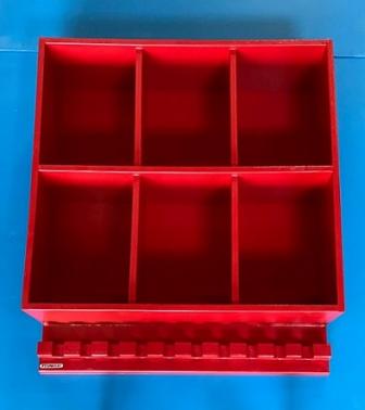 A red dugout storage rack designed to hold baseball or softball helmets and bats, with multiple compartments.