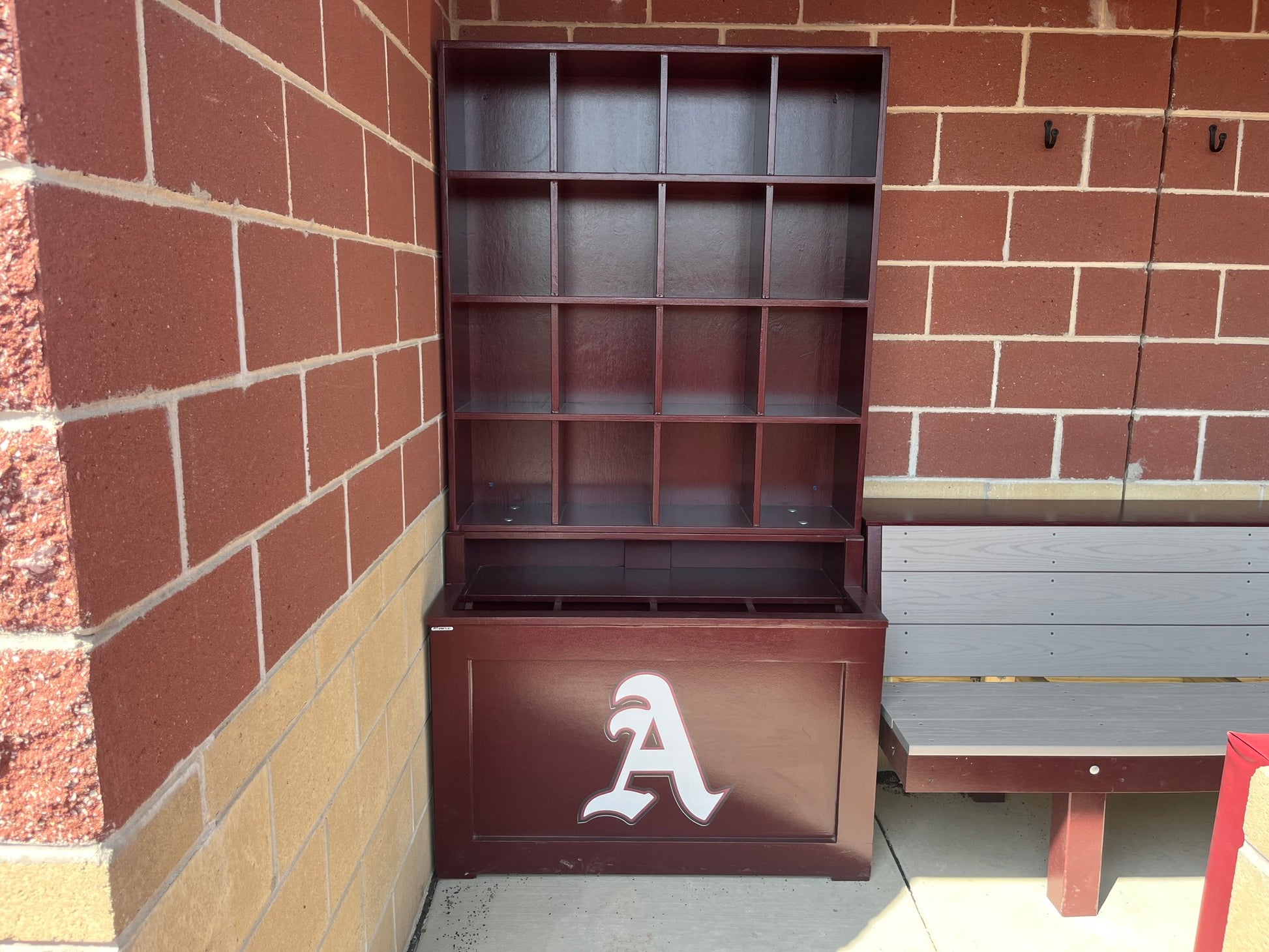 Brown storage unit with a white 'A' logo against a brick wall.