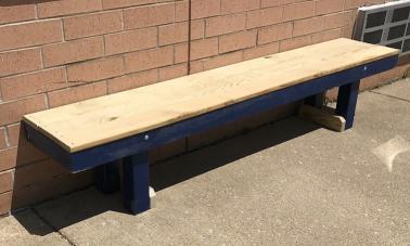 Players Bullpen Bench made with a wood frame, resting on a concrete surface.