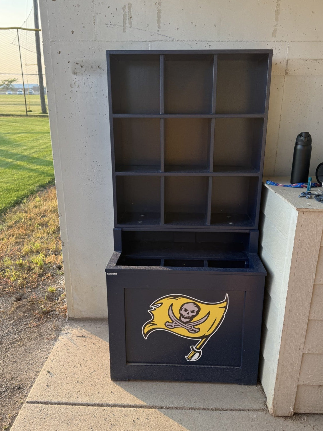 Black storage unit with a logo on a concrete surface outdoors
