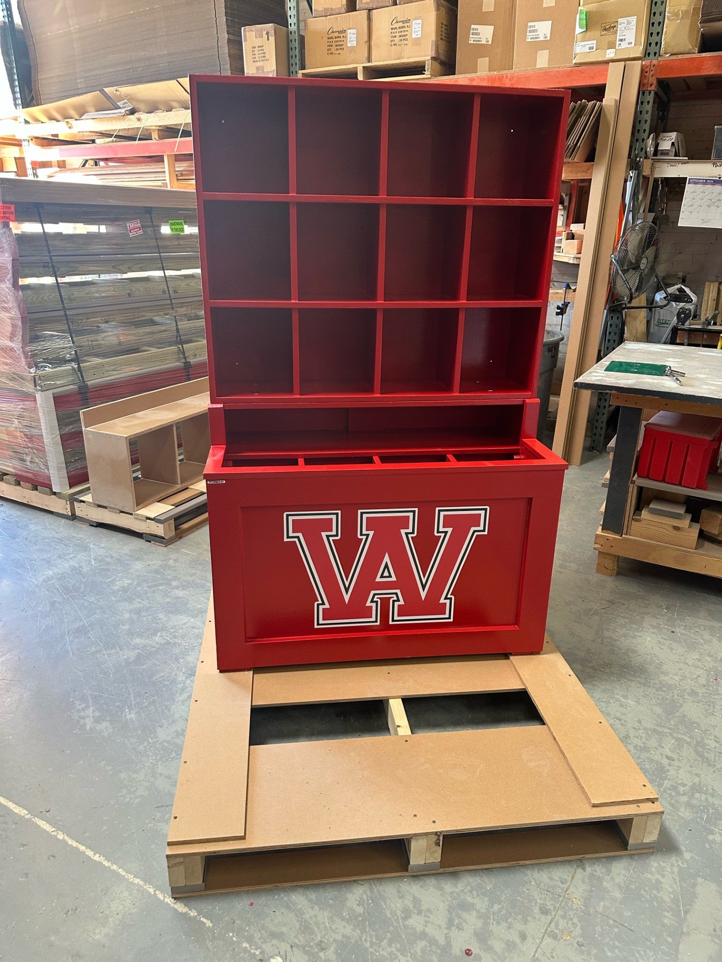 Red storage unit with 'W' logo on a pallet in an indoor setting